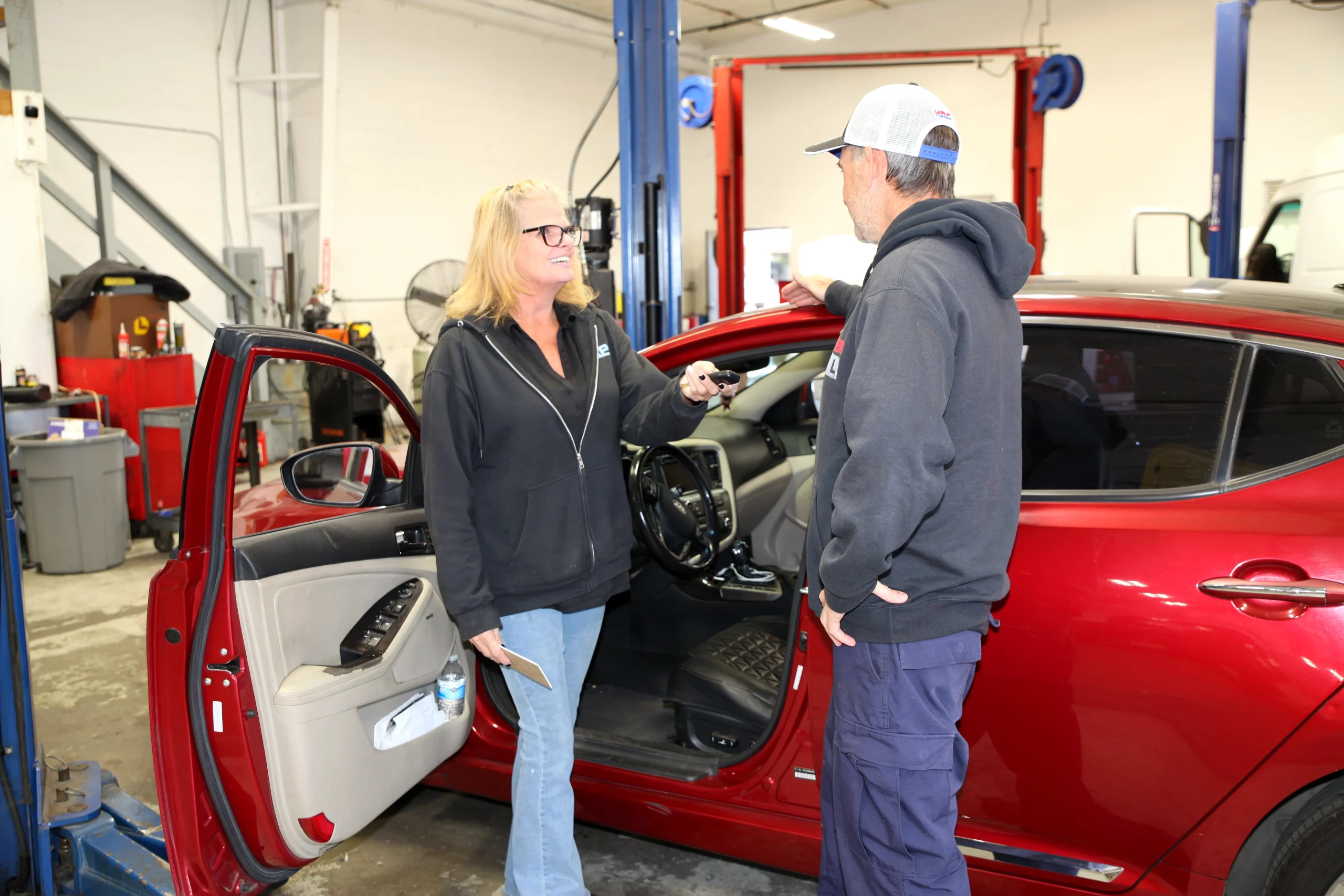 Customer talking with a technician beside a car